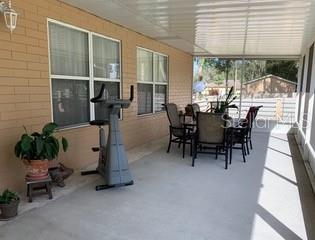 Covered patio with dining table and exercise bike.