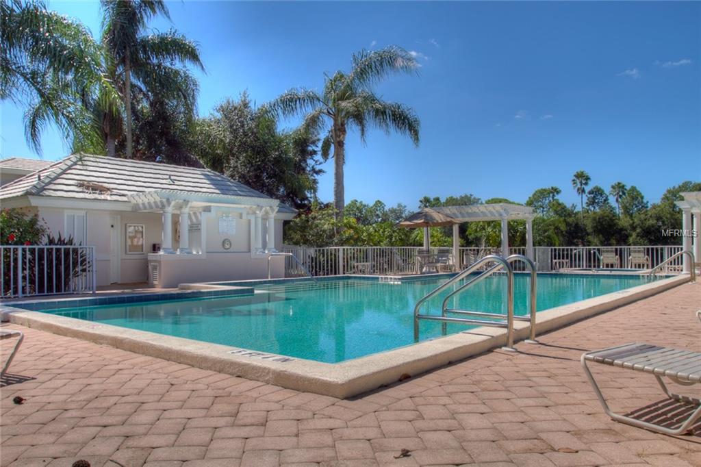 A swimming pool with a white building.