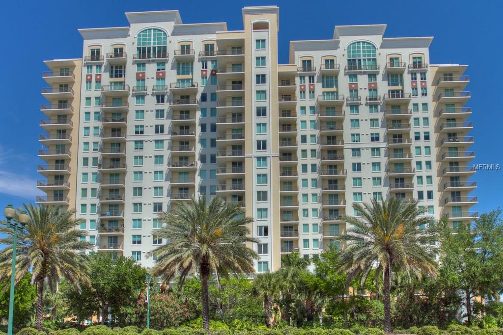 Tall apartment building with palm trees.