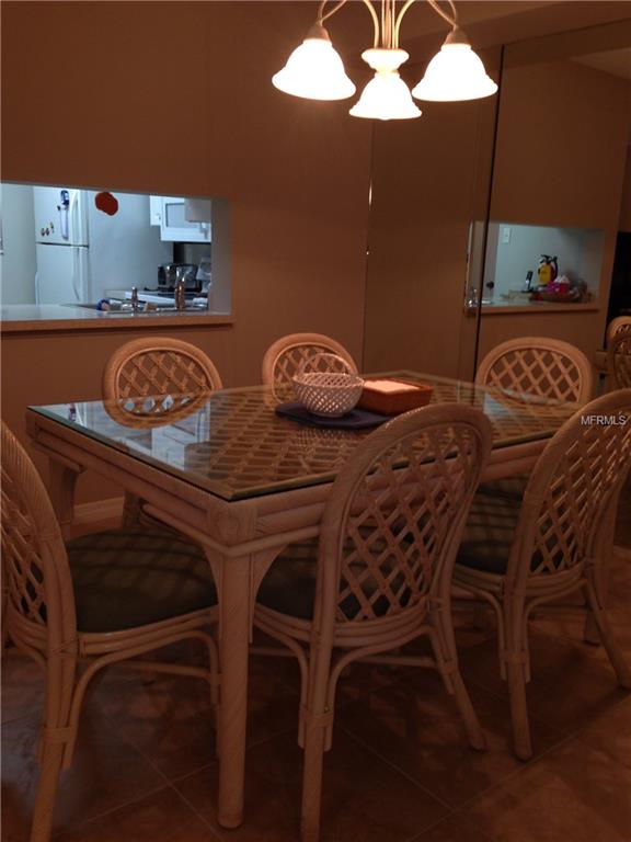 Dining room with wicker chairs and glass table.