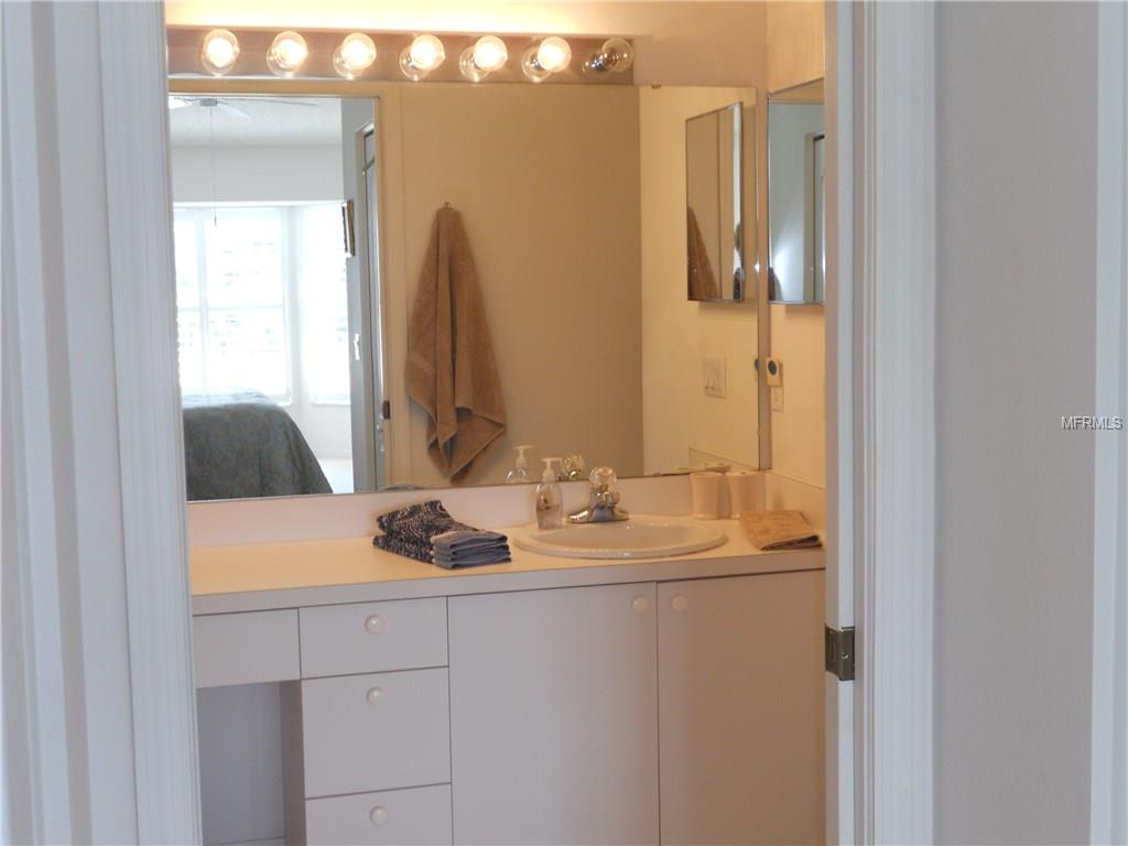 White bathroom vanity with a mirror and sink.