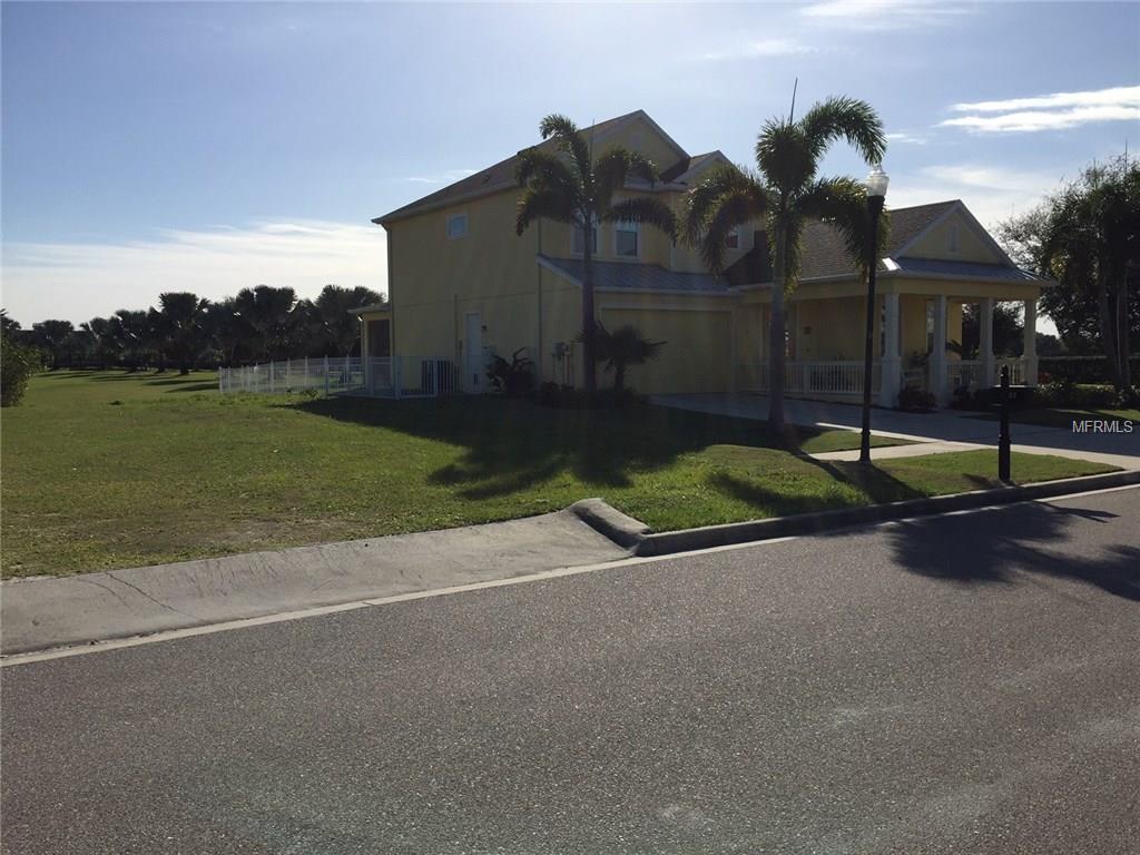 A yellow house with palm trees in front.