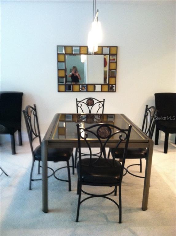 Dining room with table, chairs, and mirror.