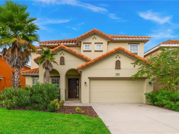 Two-story house with garage and palm trees.