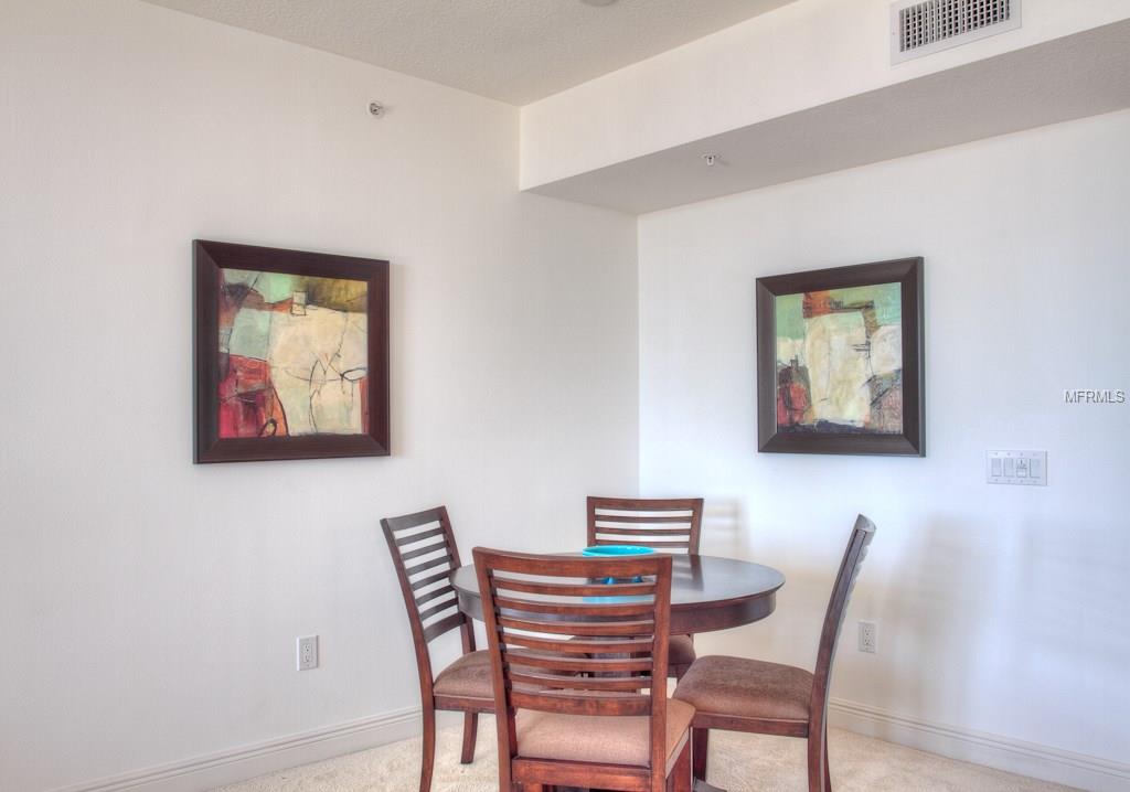 Dining room with abstract paintings and chairs.