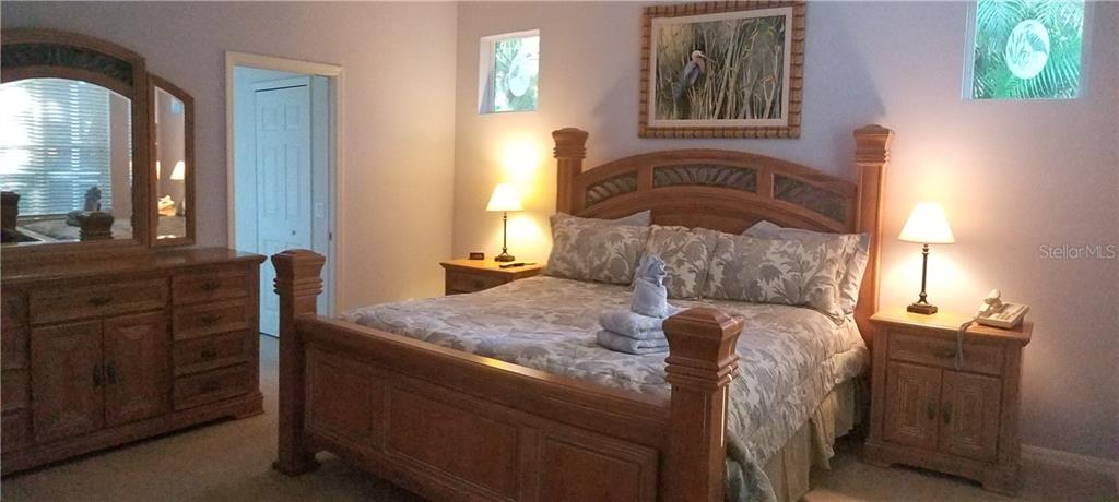 Bedroom with king bed and dresser.