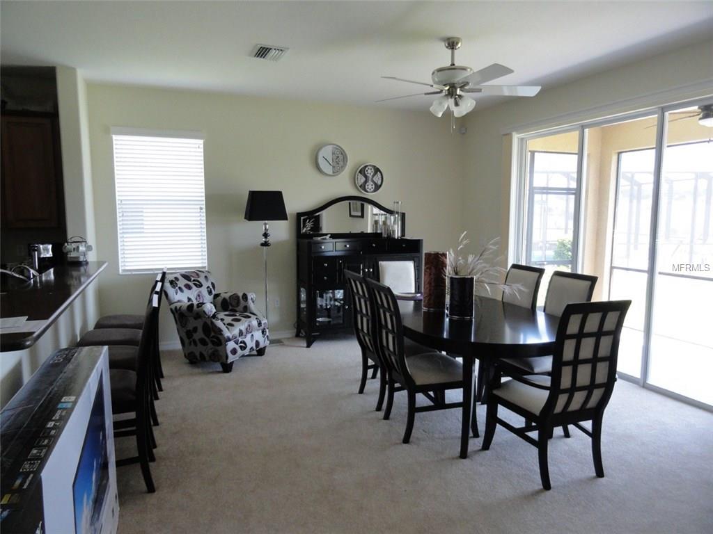 Dining room with a ceiling fan and glass doors.