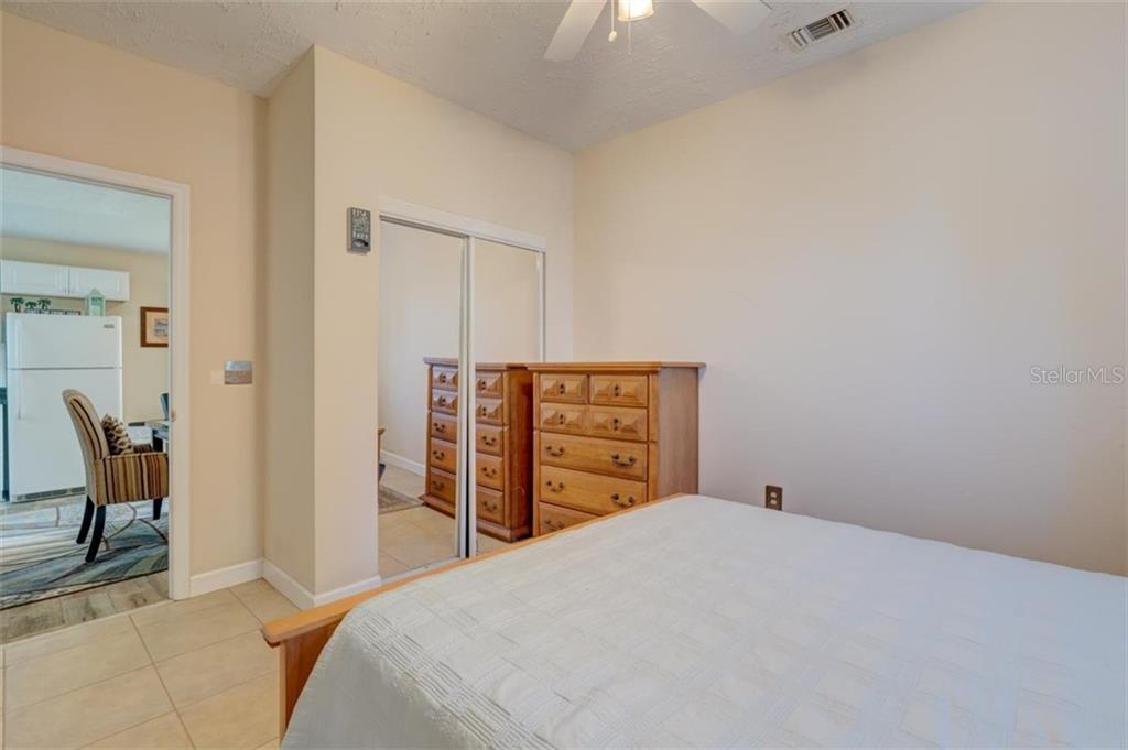 Bedroom with white bed and dresser.