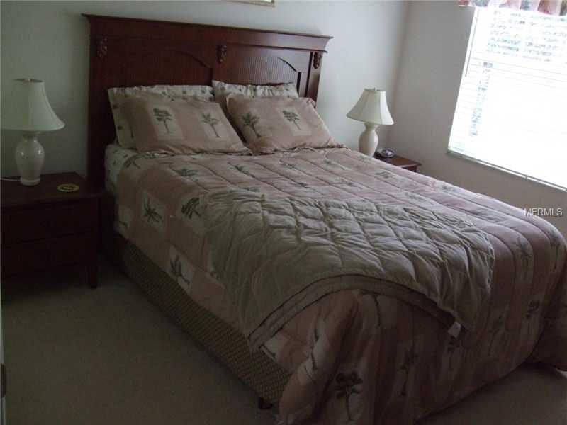 Bed with floral bedding and a nightstand.