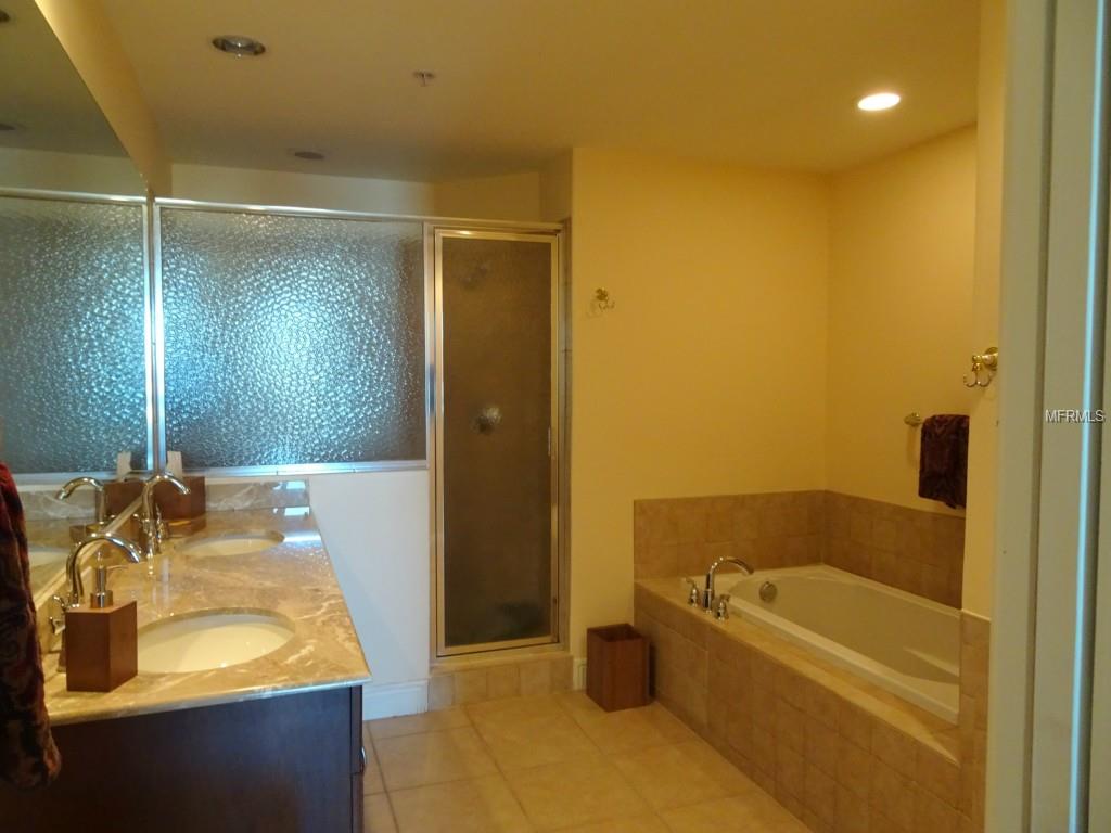 Modern bathroom with double sinks and tub.