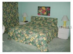 A bedroom with a floral bedspread and nightstands.