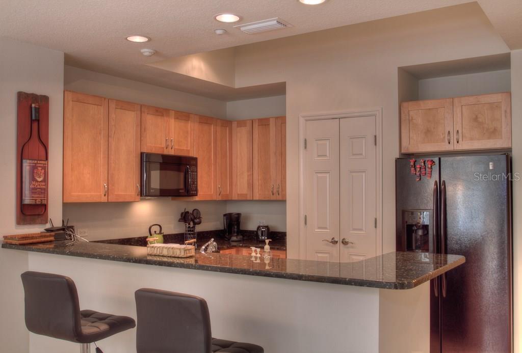 Modern kitchen with wood cabinets and granite counters.