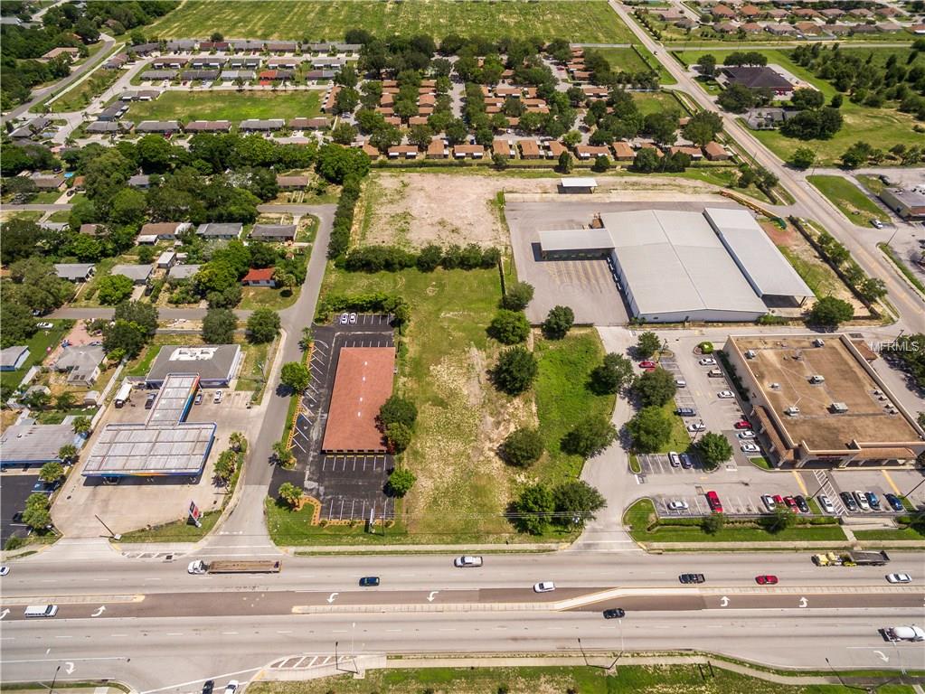 Aerial view of vacant lot near businesses.