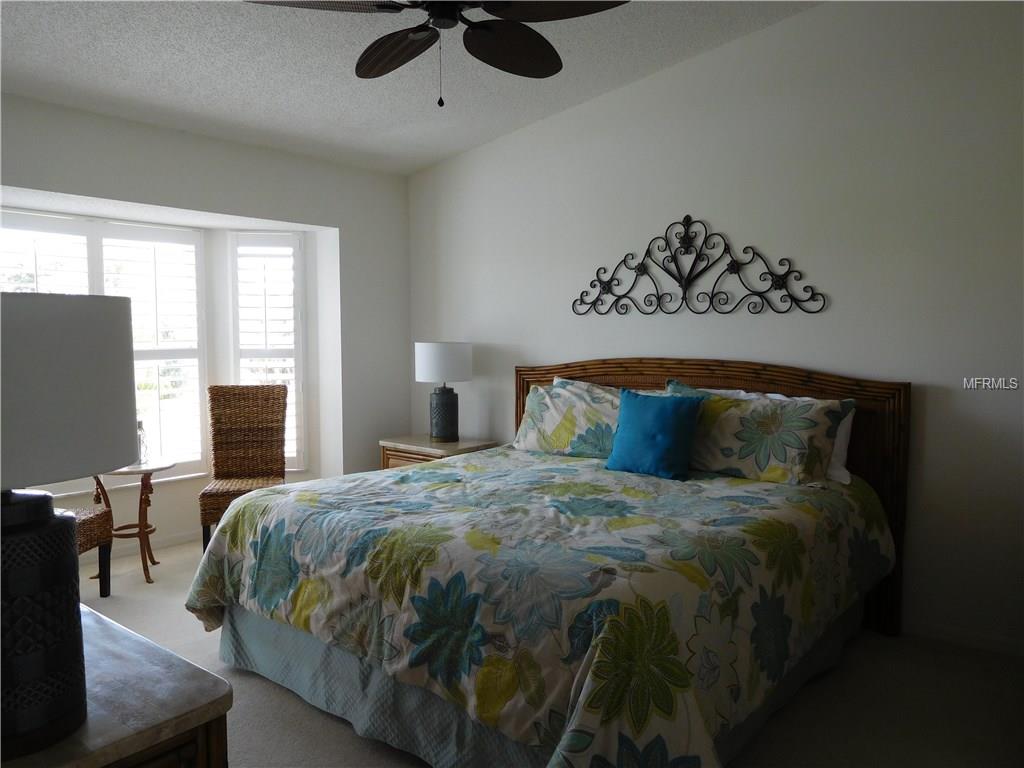 Bedroom with floral bedding and a ceiling fan.