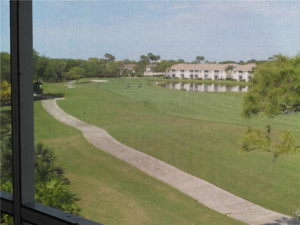 View of golf course with buildings in background.