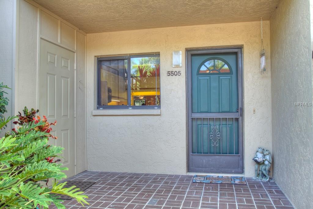 Exterior of a condo with a green door.