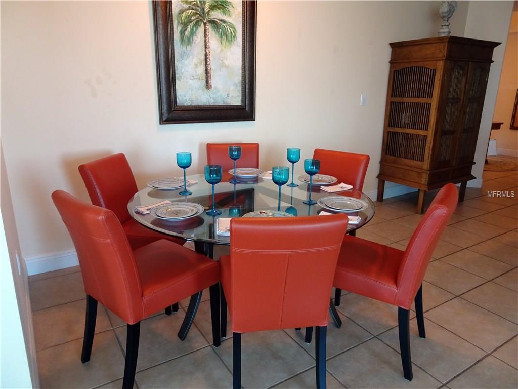 Dining room table with six red chairs.