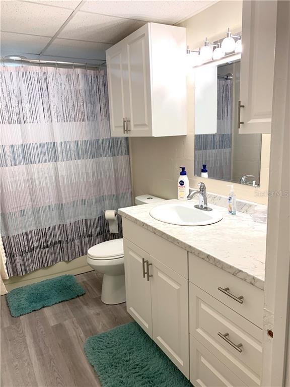 White bathroom with a vanity and shower curtain.