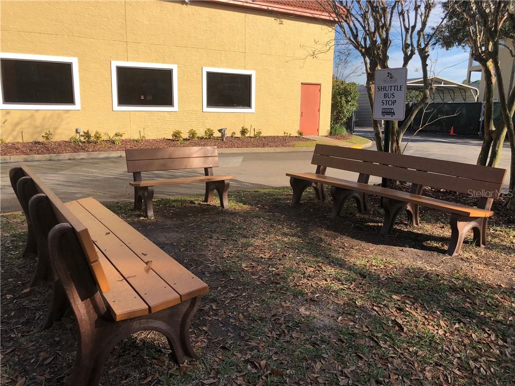 Four benches near a shuttle bus stop.