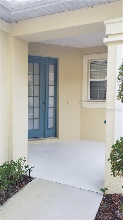 Front porch with blue door and window.