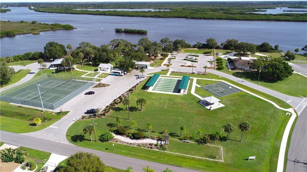 Aerial view of park with tennis court and river.