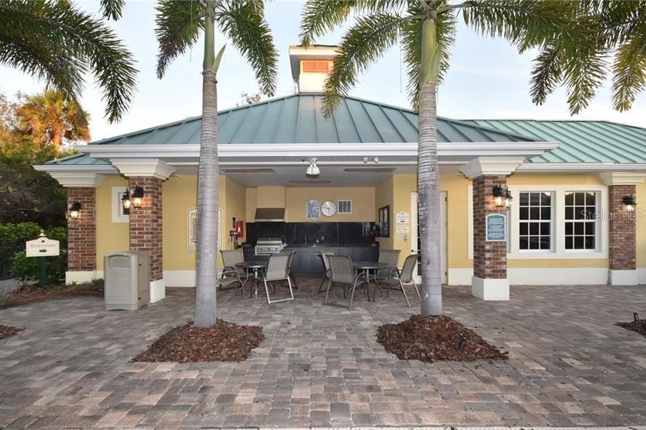 Outdoor patio with brick floor and grill area.