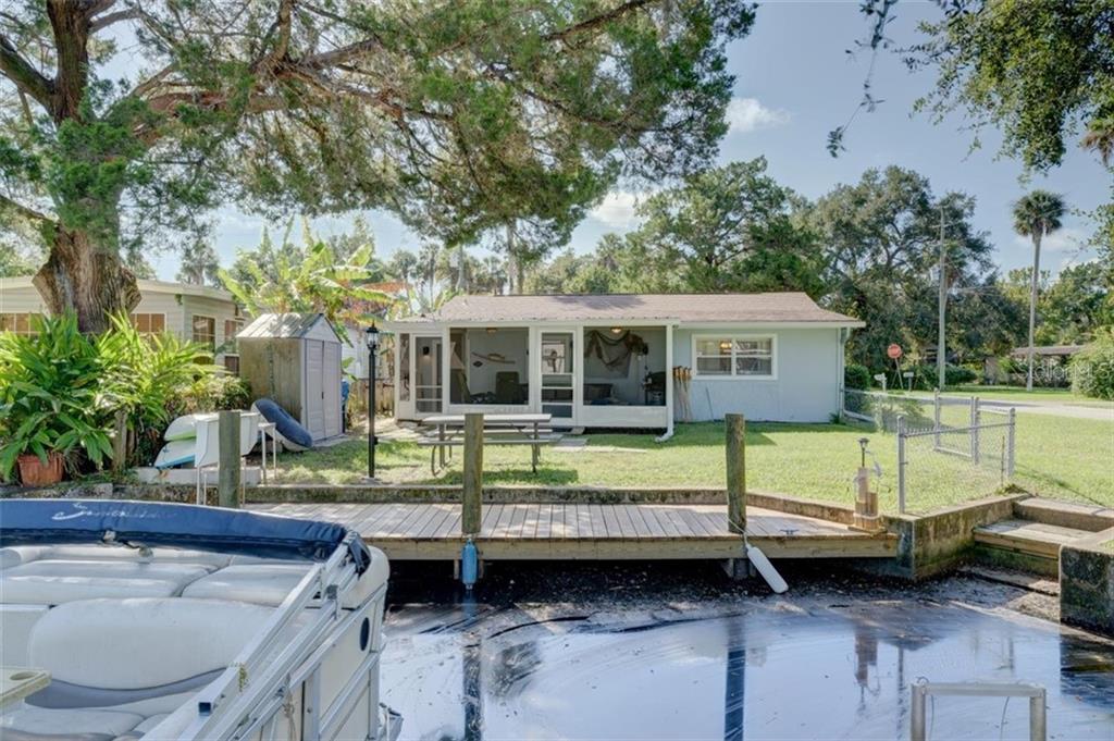 A blue house with a dock and boat.