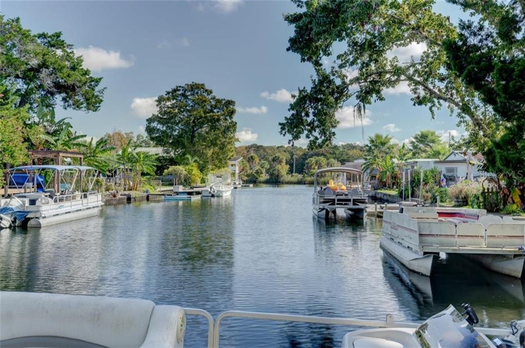 Boats docked in a canal with homes.