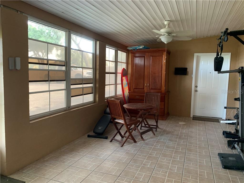 Tiled room with furniture and windows.