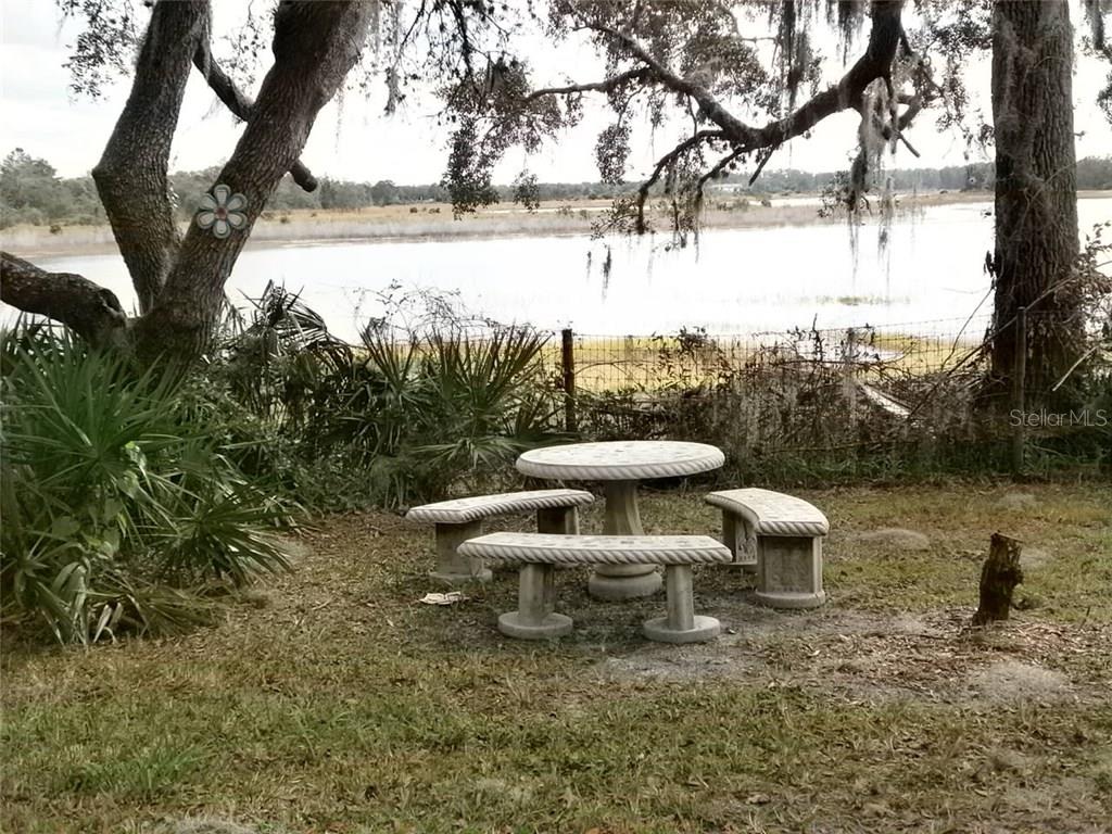 Concrete table and benches by a lake.