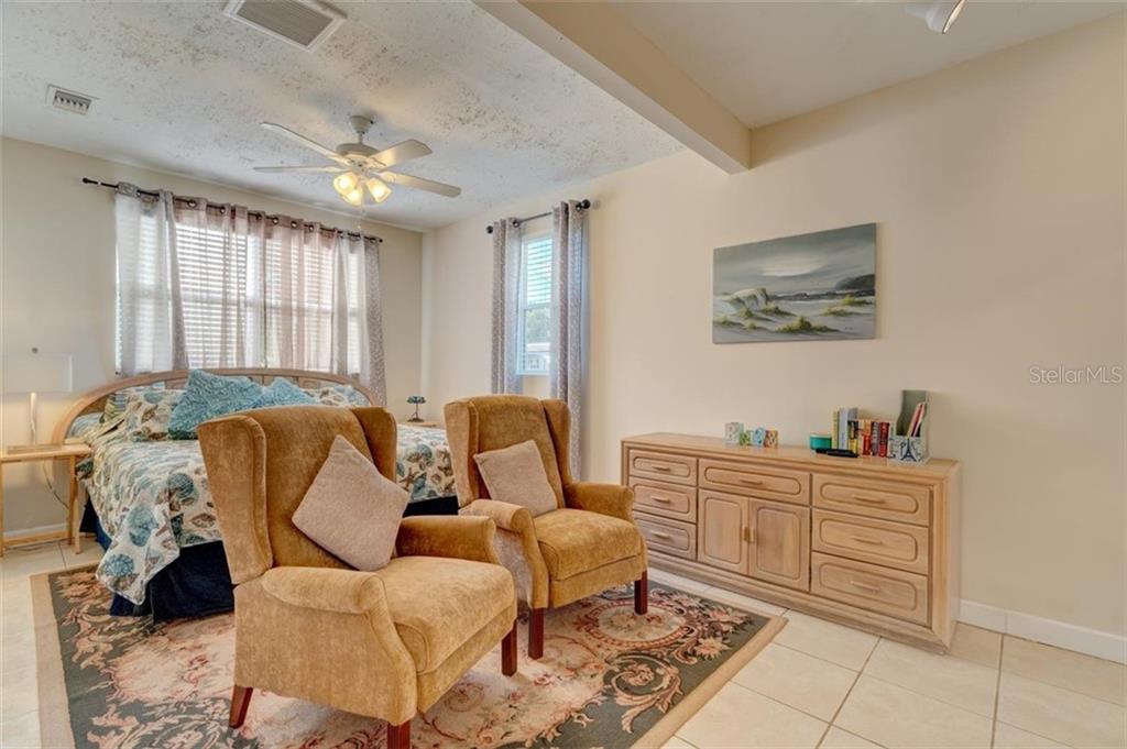 Two armchairs in a furnished bedroom.