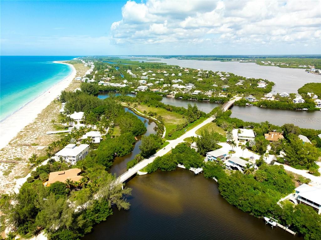 Aerial view of waterfront homes and a bridge.