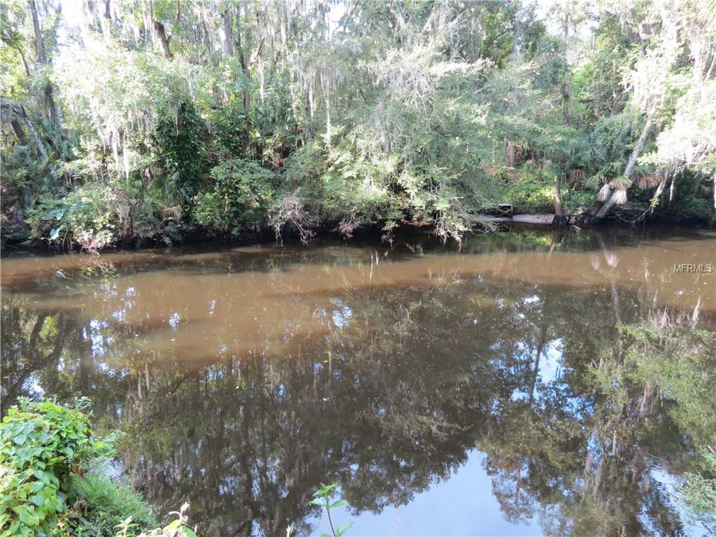 Calm river with trees reflected in the water.