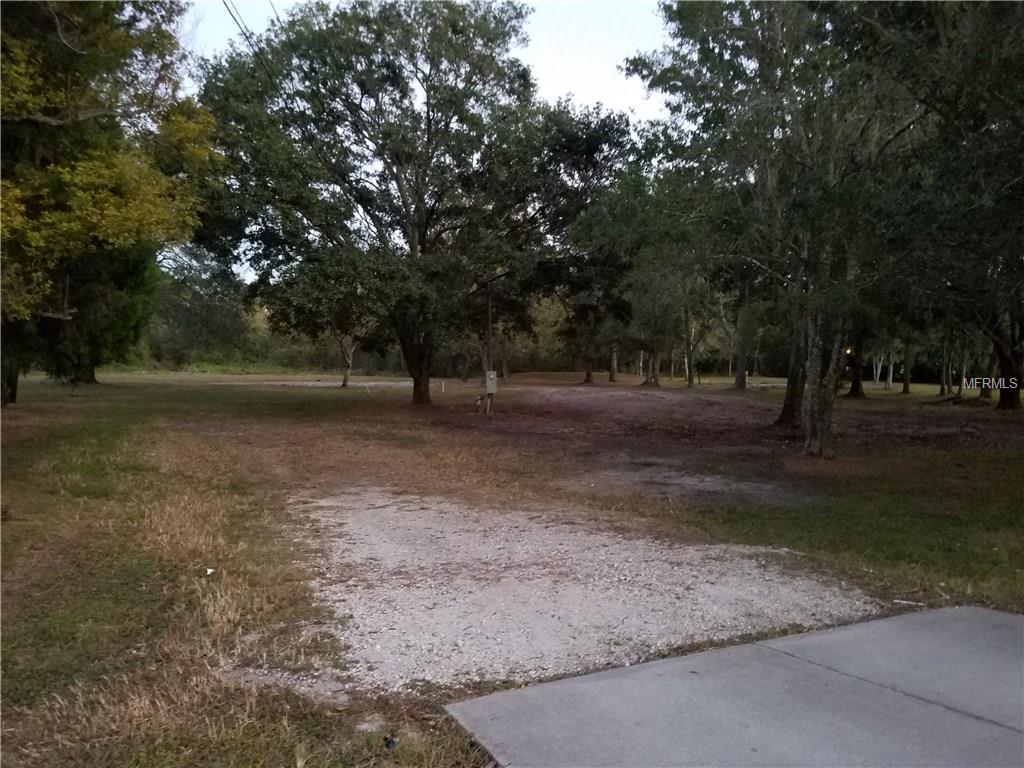 Gravel driveway leading to a grassy lot.