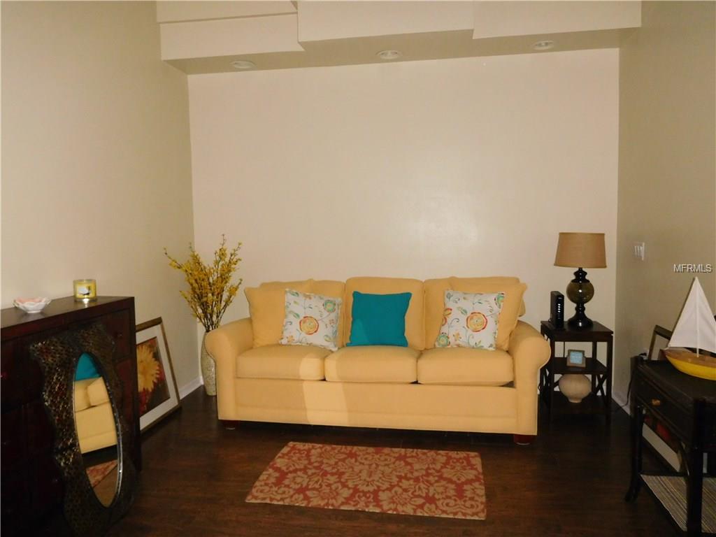 Yellow couch in a living room with a rug.