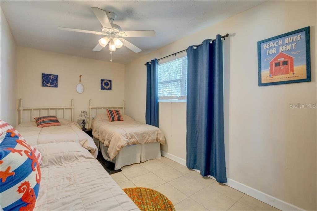 Two beds in a beach themed bedroom.