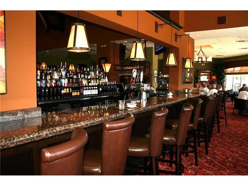 Bar counter with leather stools and liquor bottles.