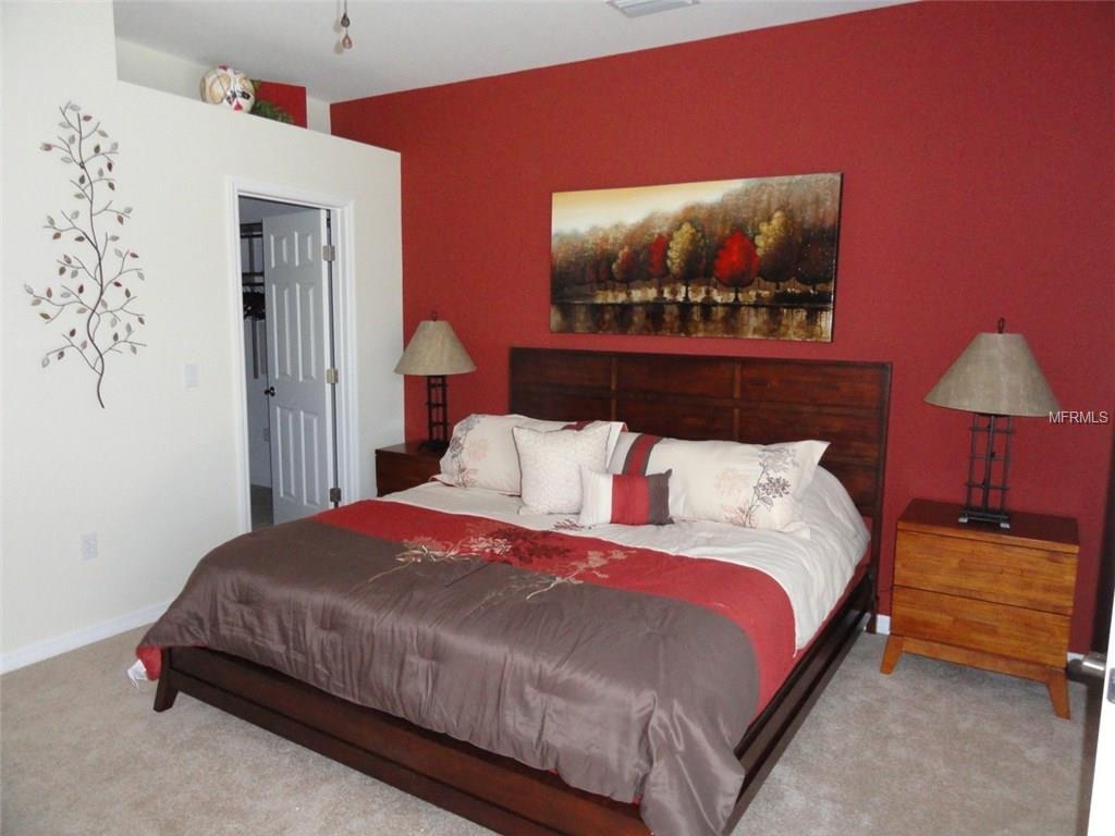 Bedroom with king size bed and red walls.