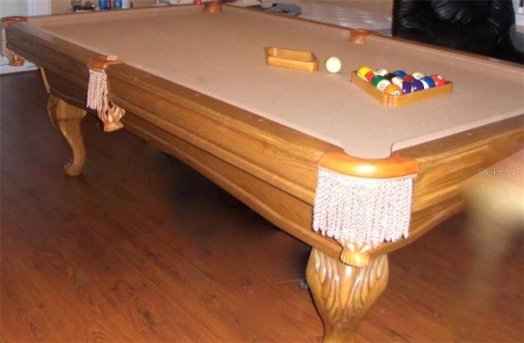 Wooden pool table with white balls.