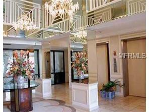 Elegant lobby with elevator and chandelier.