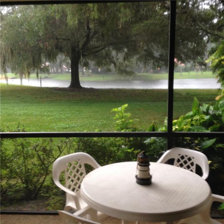 Rainy view from patio with white table and chairs.