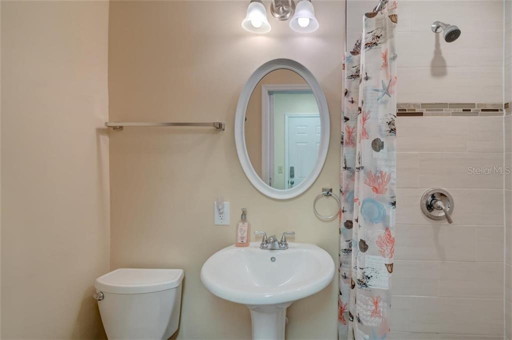 A bathroom with a sink, toilet, and shower.