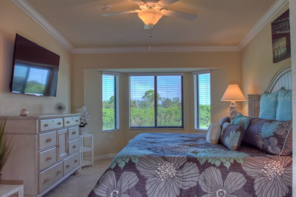 Bedroom with floral bedding and a large window.