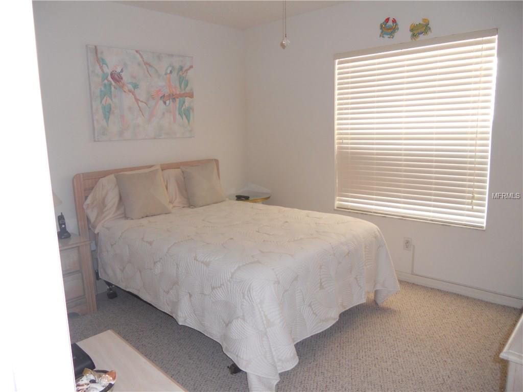 White bed with floral bedding in a bedroom.