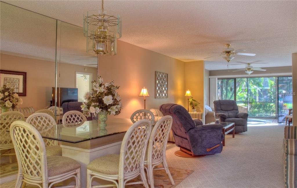 Dining room with wicker chairs and a glass table.