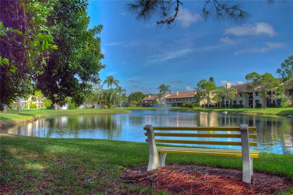 Yellow bench by a lake and condos.