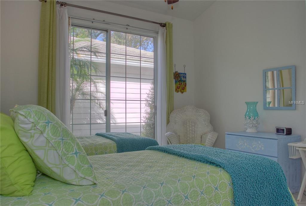 Bedroom with two beds and a sliding door.