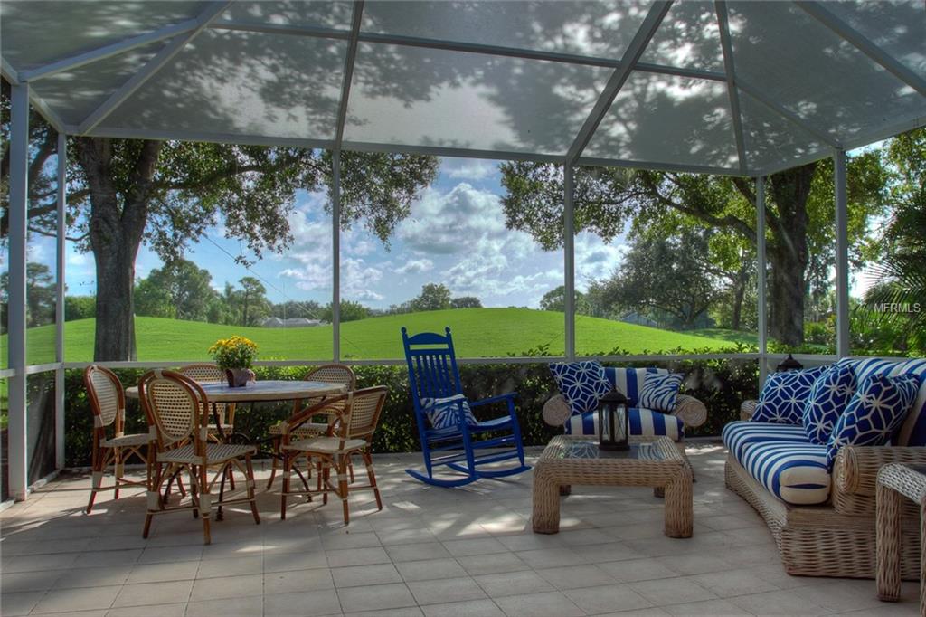 Enclosed patio with blue rocking chair and view.