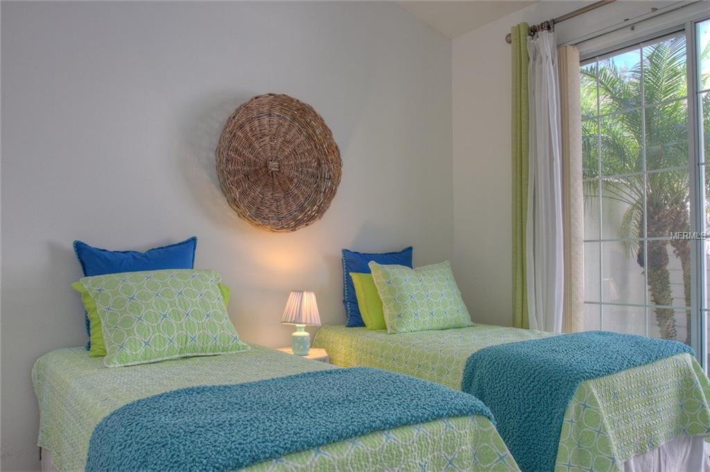 Two twin beds with green and blue bedding.