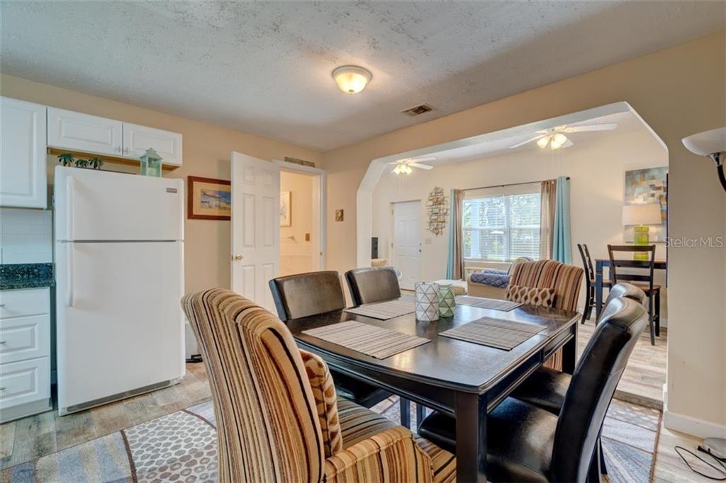 Dining room with table, chairs and fridge.